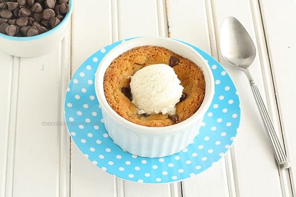 A ramekin filled with baked chocolate cookie dough and a scoop of ice cream.