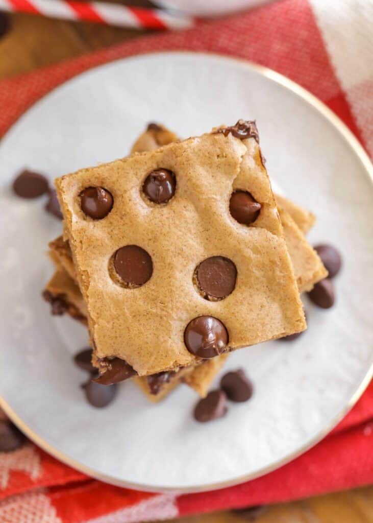 A top down shot of chocolate chip cookie bars on a white plate.
