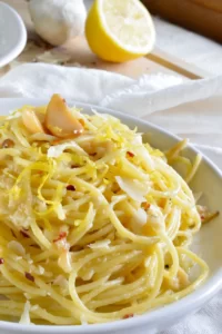 Lemon Garlic Pasta piled on a white dinner plate.
