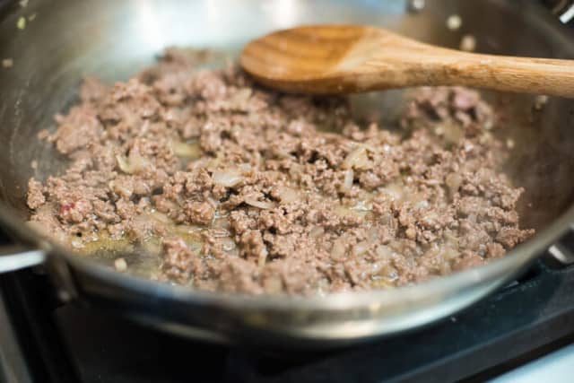The browned ground beef in the skillet.