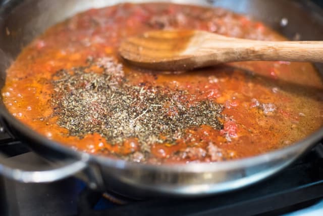 Tomato sauce, beef broth and seasonings are added to the skillet.
