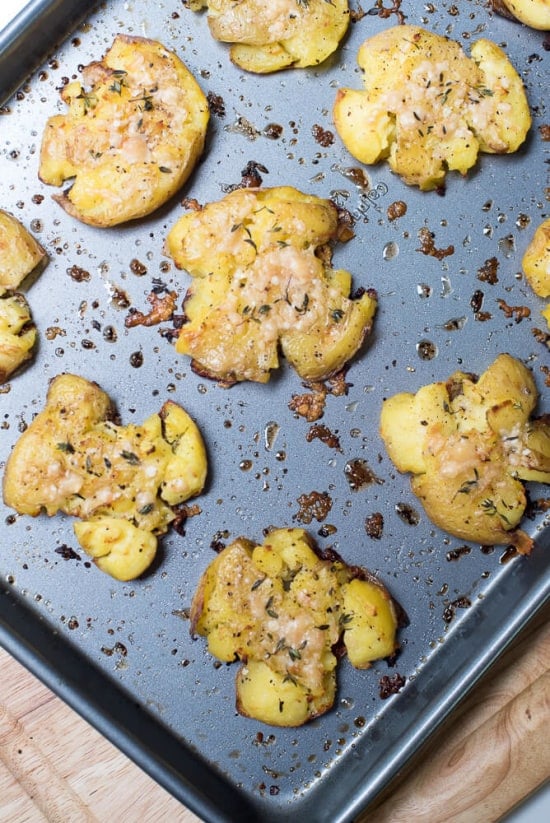 Crispy Parmesan Smashed Potatoes on a baking sheet shot from over the top.