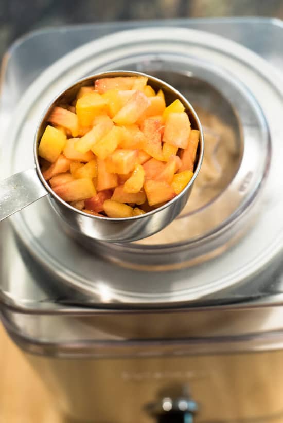 Fresh chopped peaches are added to the ice cream maker.