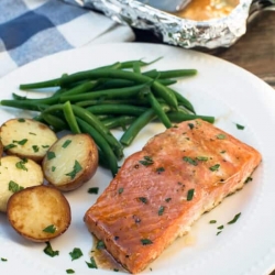 Salmon, potatoes and green beans on a white plate.