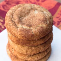 A stack of Pumpkin Spice Snickerdoodles on a square of parchment paper.