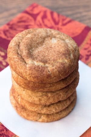 A stack of Pumpkin Spice Snickerdoodles on a square of parchment paper.