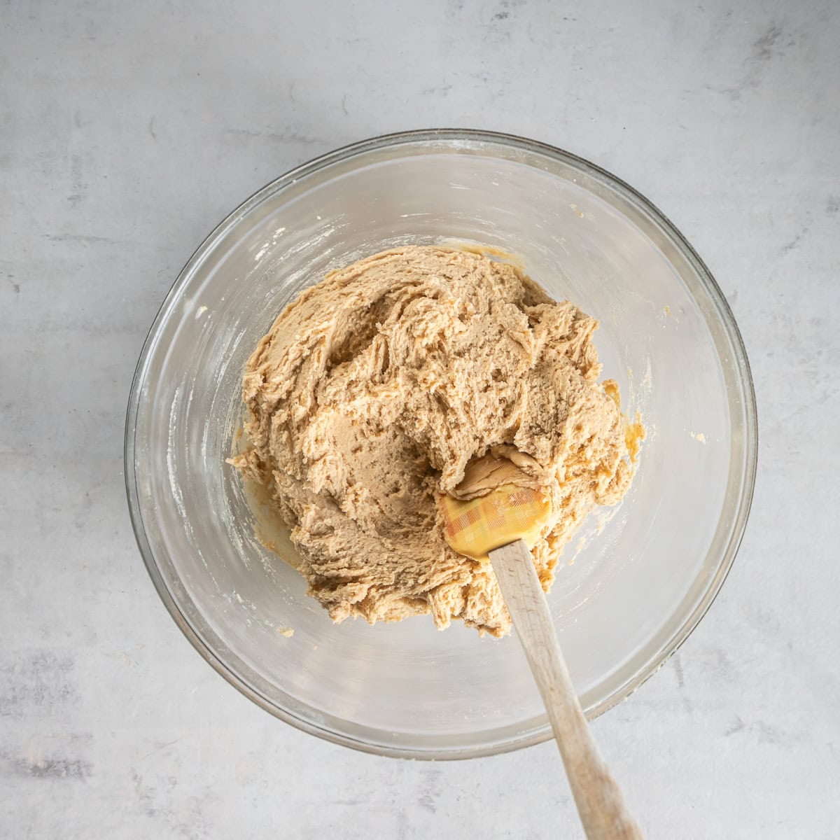 Pumpkin spice snickerdoodle dough in a glass mixing bowl, ready to cover and chill.