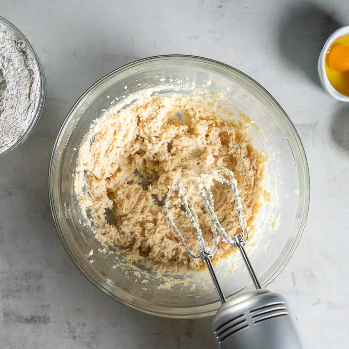 Butter, granulated sugar, and brown sugar creamed together in a glass mixing bowl.