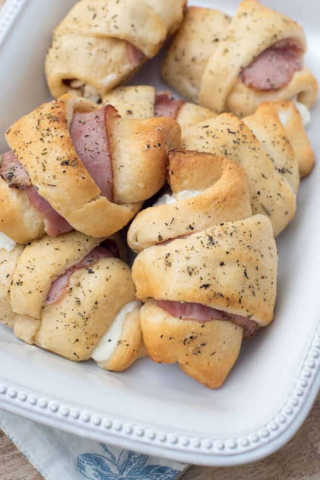 The baked stuffed crescents in a white serving dish.