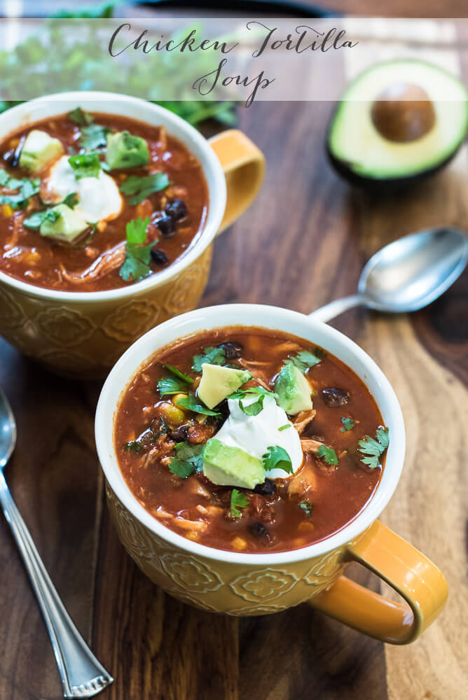 Chicken Tortilla Soup in yellow mugs topped with sour cream, cilantro, and avocado.