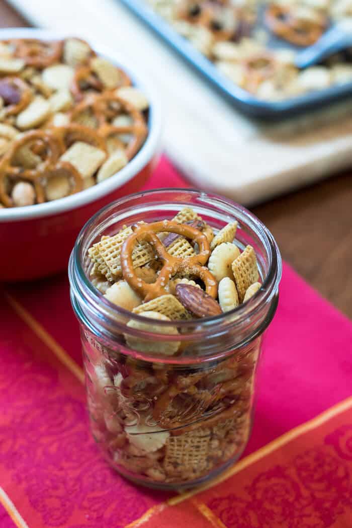 Garlic Dill Snack Mix in a mason jar on a red cloth.