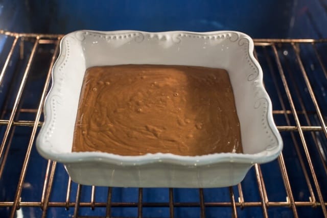 The gingerbread batter in a baking dish in the oven.