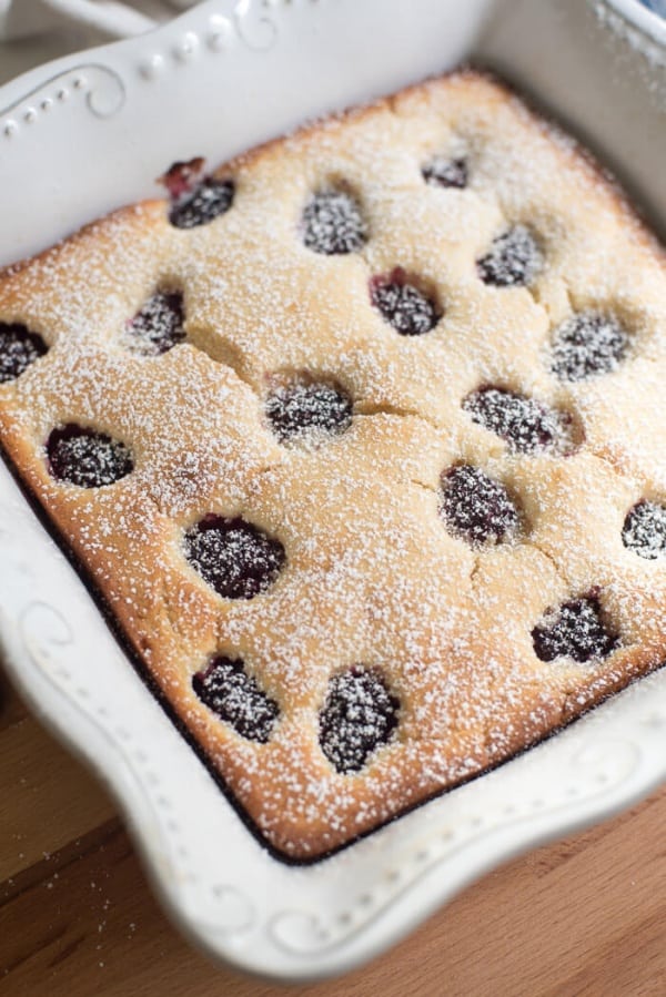 Blackberry Buttermilk Snack Cake in a white baking dish shot from the side.