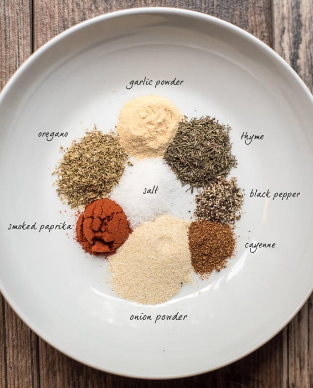 Kickin' Cajun Spice Mix ingredients on a white plate with text overlay.