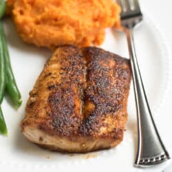 A piece of Blackened Mahi Mahi on a plate with mashed sweet potatoes.