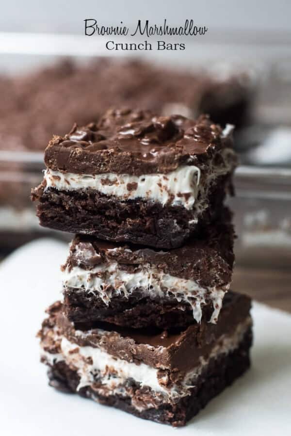Brownie Marshmallow Crunch Brownies stacked on a white plate.
