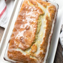 A loaf of lemon yogurt poppy seed bread topped with glaze.