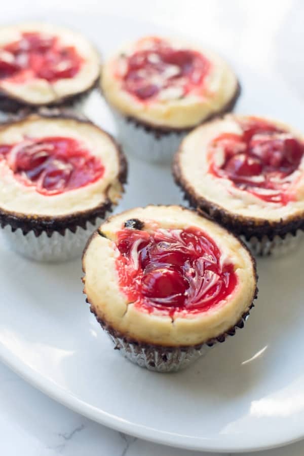 Cherry Cheesecake Brownie Cupcakes on a white platter.