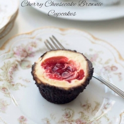 A brownie cupcake with cherry cheesecake filling on a pretty china plate.