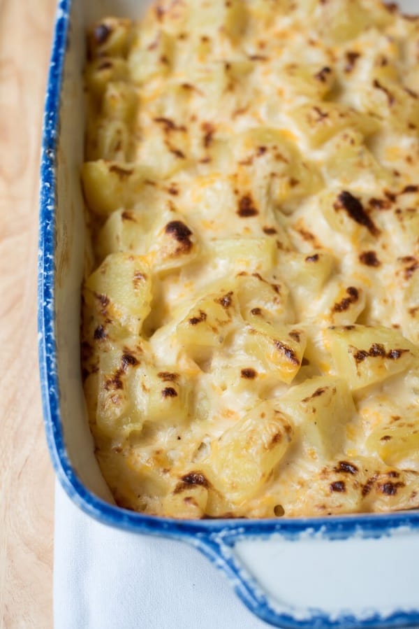 A close up of Au Gratin Potatoes in a blue and white baking dish.