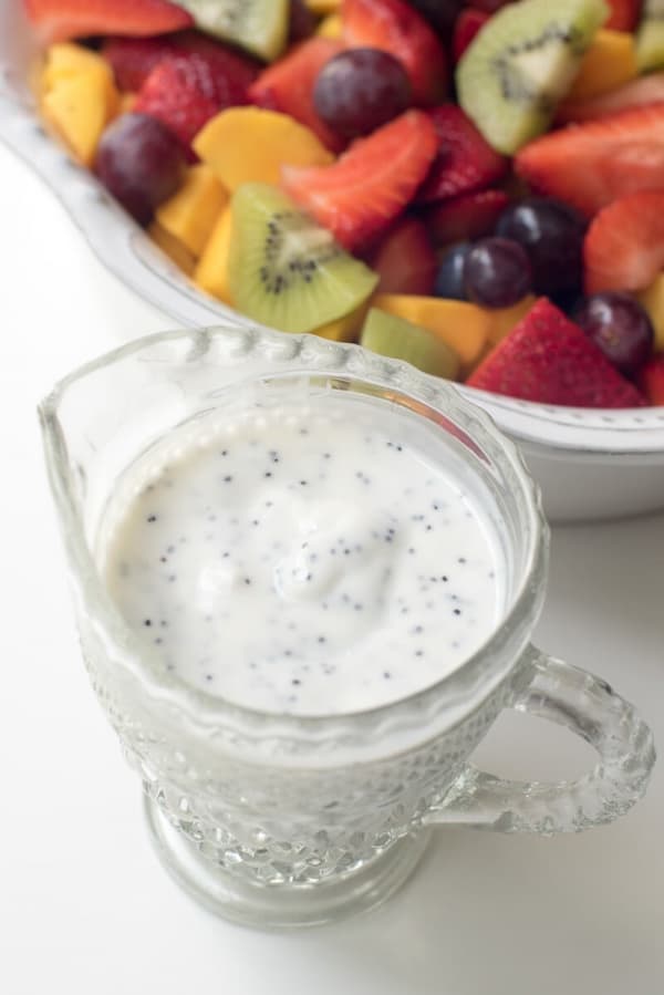 A close up of the poppy seed dressing in a handled crystal container.