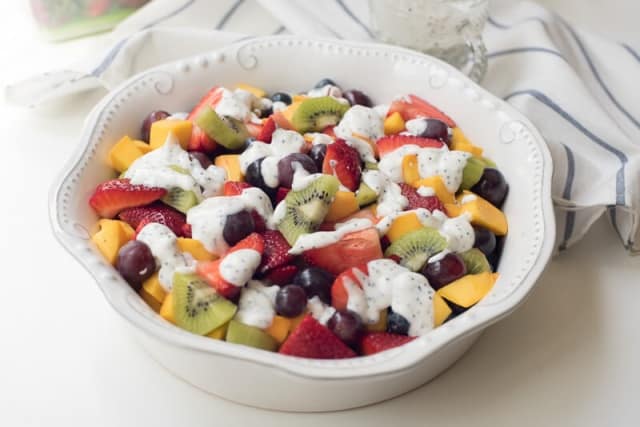 Fruit Salad with Creamy Poppy Seed Dressing in a white bowl.