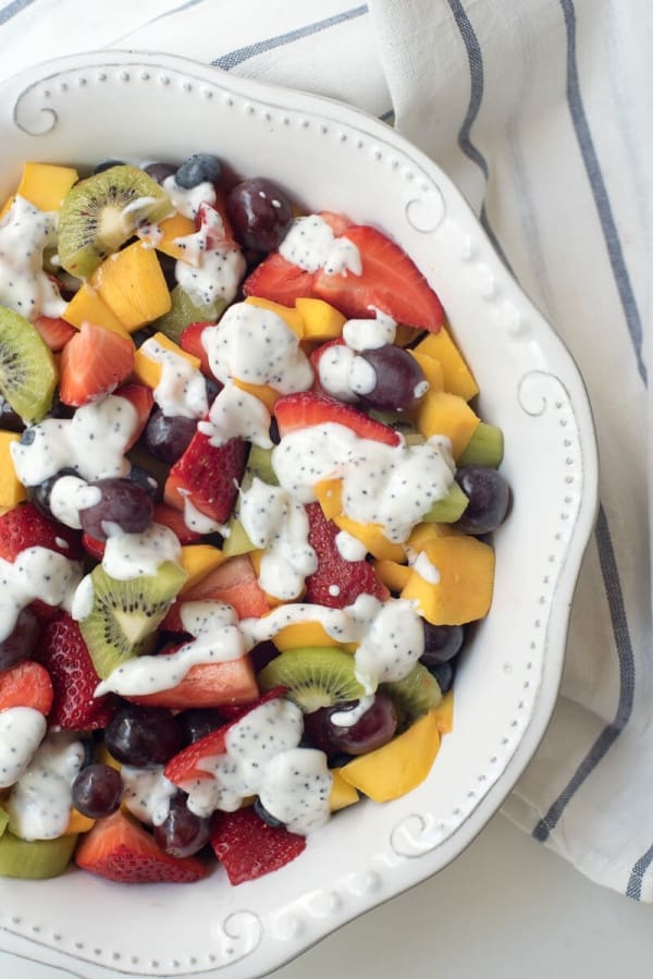 An over the top shot of the Fruit Salad with Creamy Poppy Seed Dressing in a white bowl.