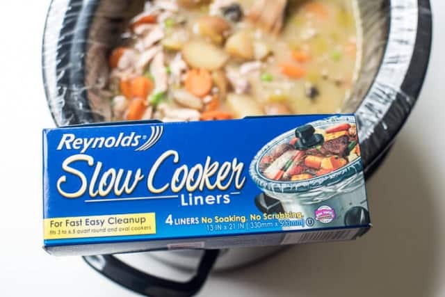 A box of Reynold's Slow Cooker Liners balanced on a slow cooker.