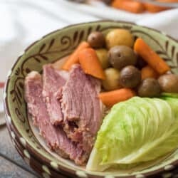 Sliced corned beef with cabbage, potatoes, and carrots in a bowl.