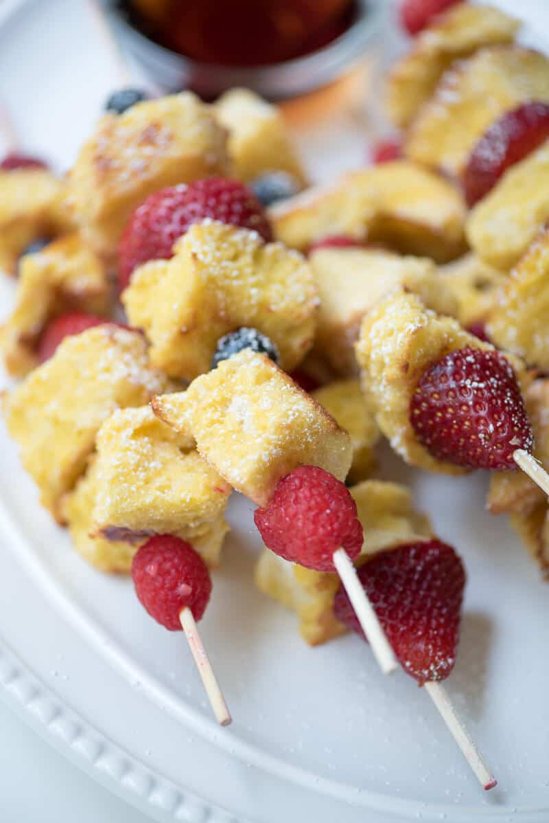 A close up of the French toast kabobs on a white plate.