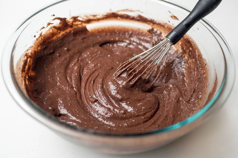 A chocolate pudding mixture is combined with a whisk.