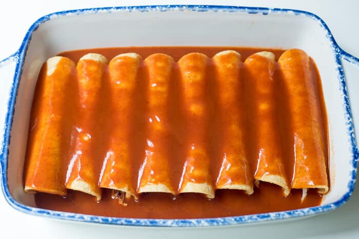 Enchilada sauce is poured over the top of the enchiladas.