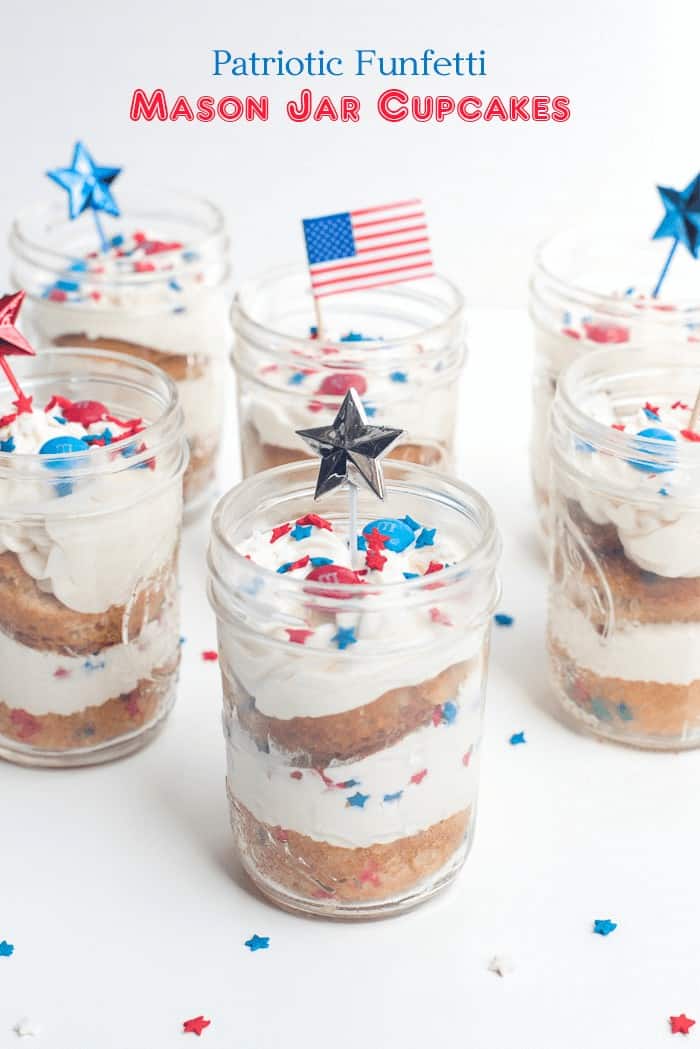 Patriotic Funfetti Mason Jar Cupcakes on a white surface with star and flag picks.