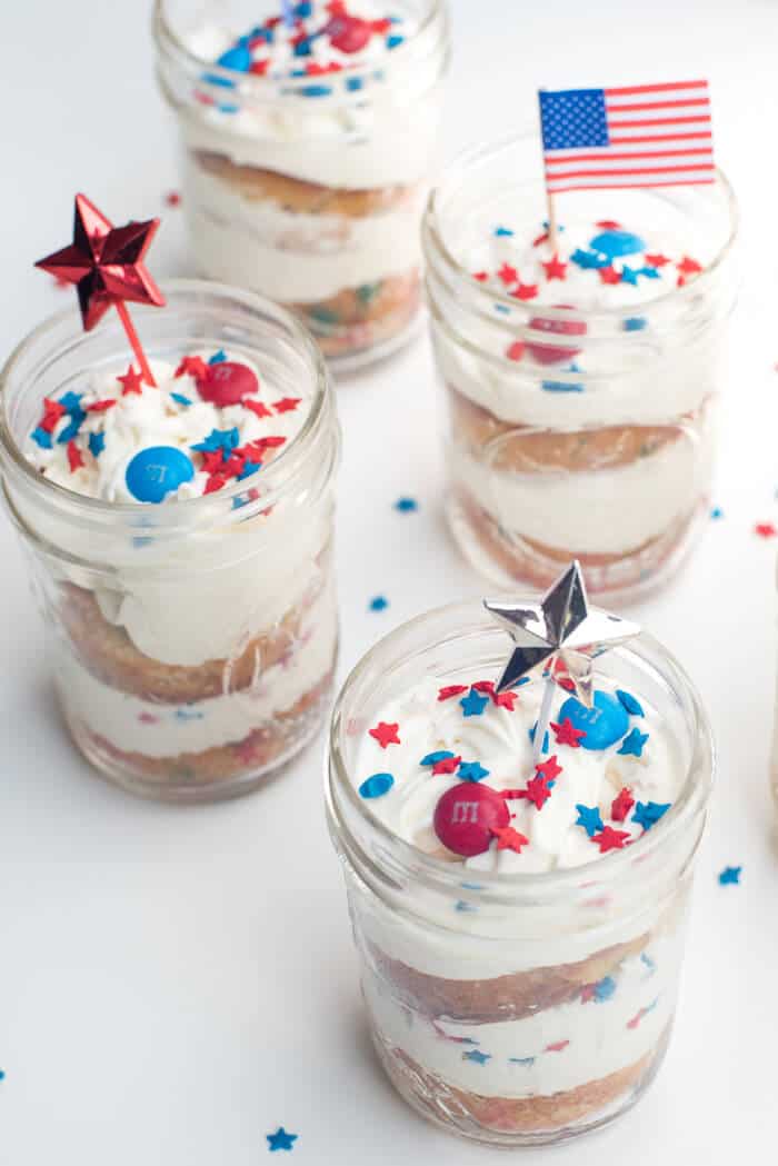 Patriotic Funfetti Mason Jar Cupcakes topped with festive star and flag picks.