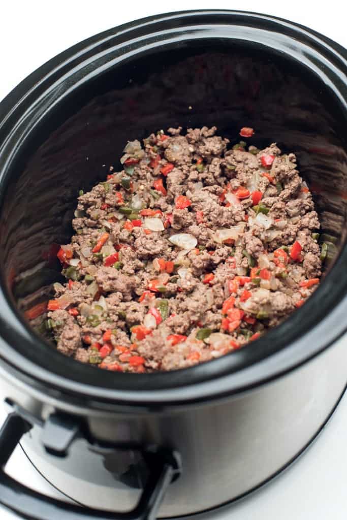Cooked ground beef, peppers and onion in the slow cooker.