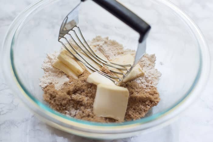 A pastry blender combines butter, flour, and brown sugar.