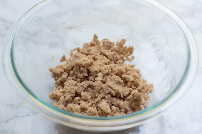 The crumb mixture after it has been combined in a glass bowl.