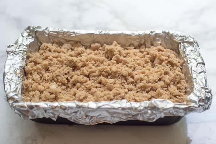 The crumb mixture on top of the cake batter in the loaf pan.