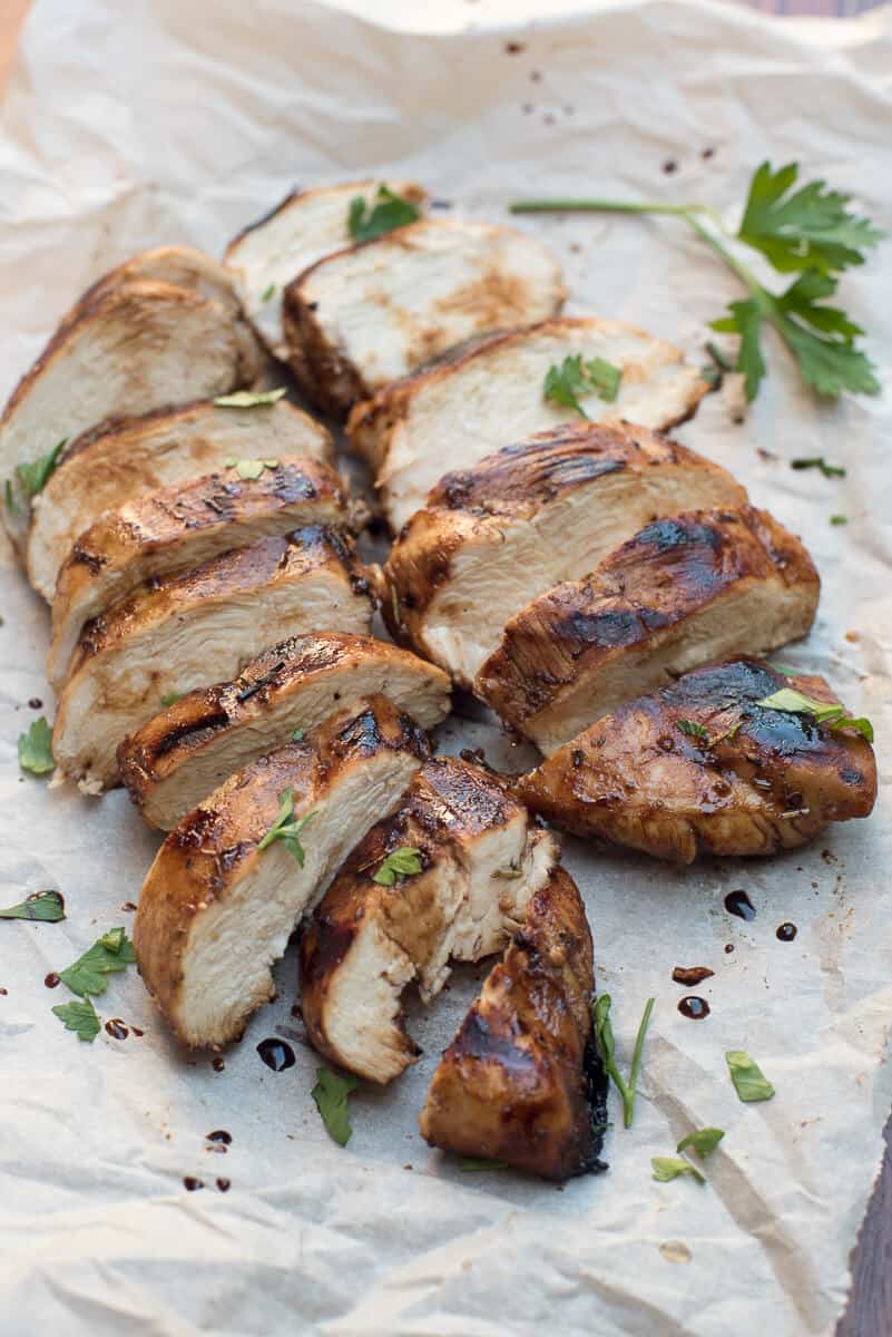 Sliced Balsamic Herb Grilled Chicken on parchment paper.