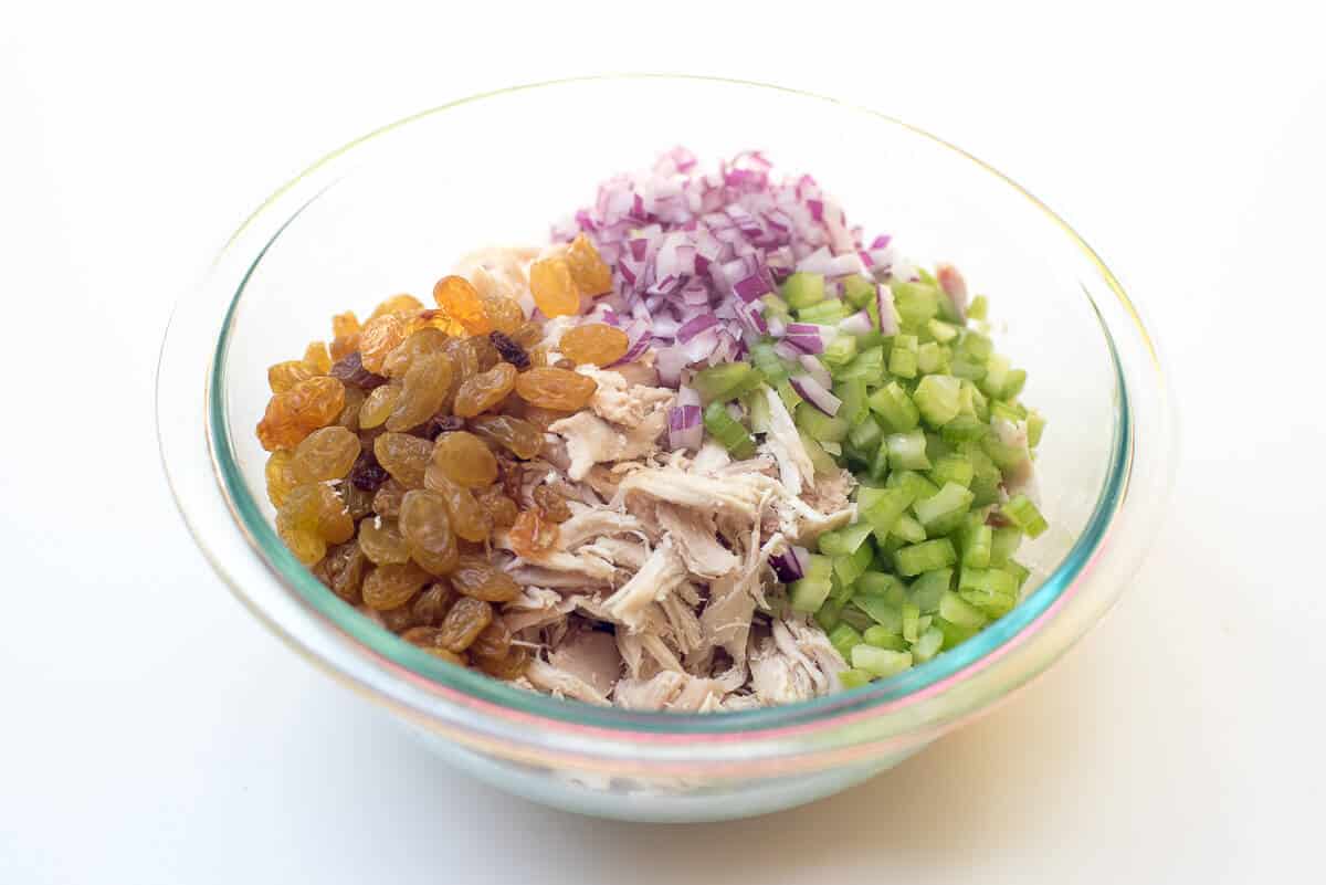 The ingredients for the chicken salad in a glass bowl.