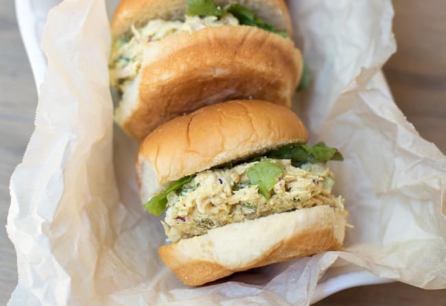 A Curry Chicken Salad Sandwich on a small bun with lettuce.