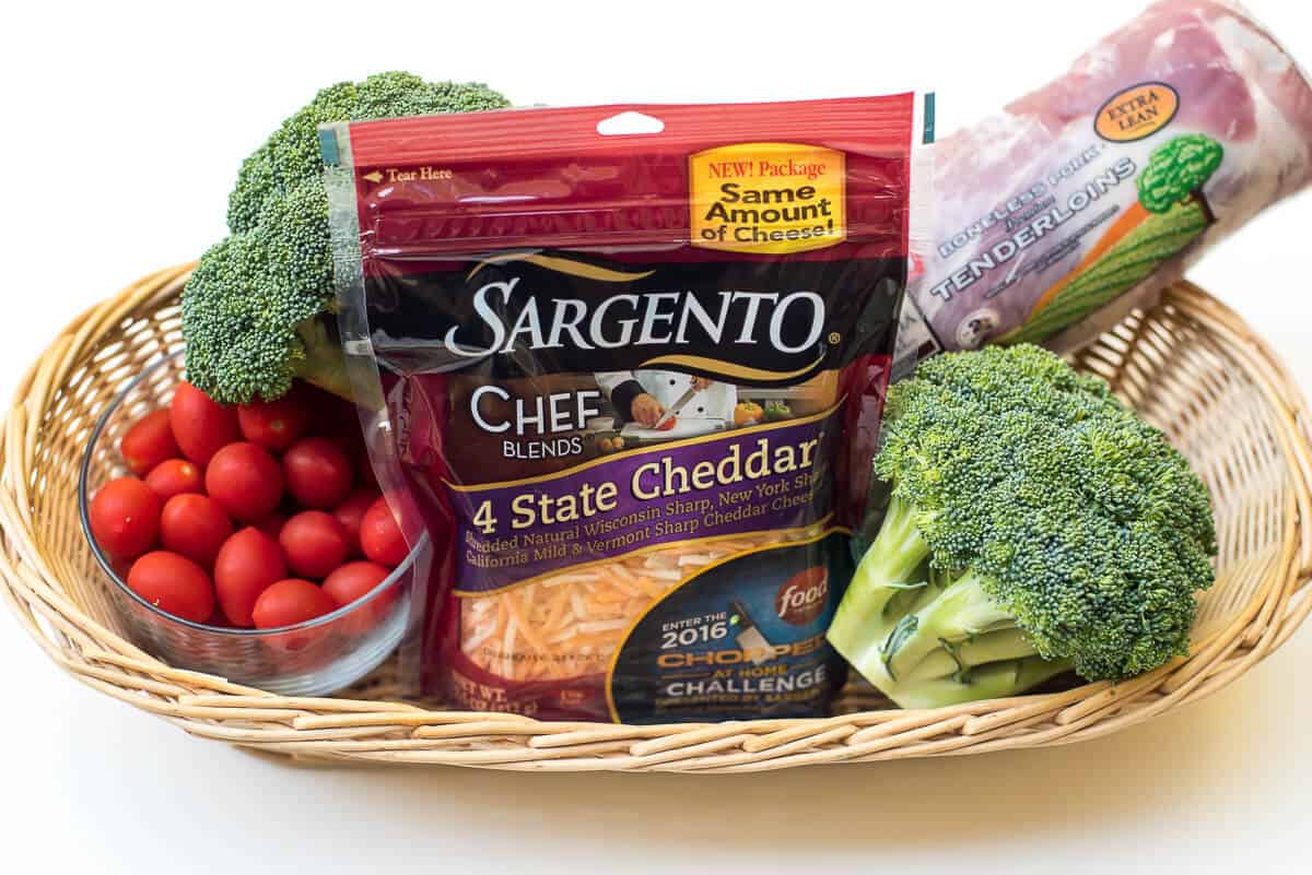 Sargento Chef Blends 4 State Cheddar, pork tenderloin, broccoli, and cherry tomatoes in a basket.