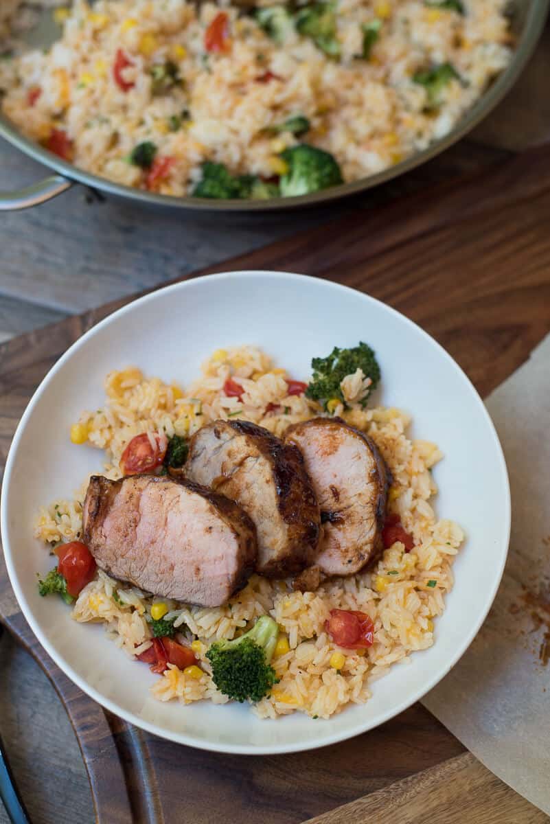 Grilled Pork Tenderloin with Cheesy Vegetable Rice in a white bowl shot from over the top.