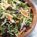 A wooden bowl filled with broccoli kale slaw.