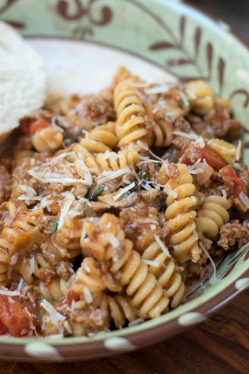 A close up of a serving of Cheesy Beef Skillet Pasta topped with shredded Parmesan.