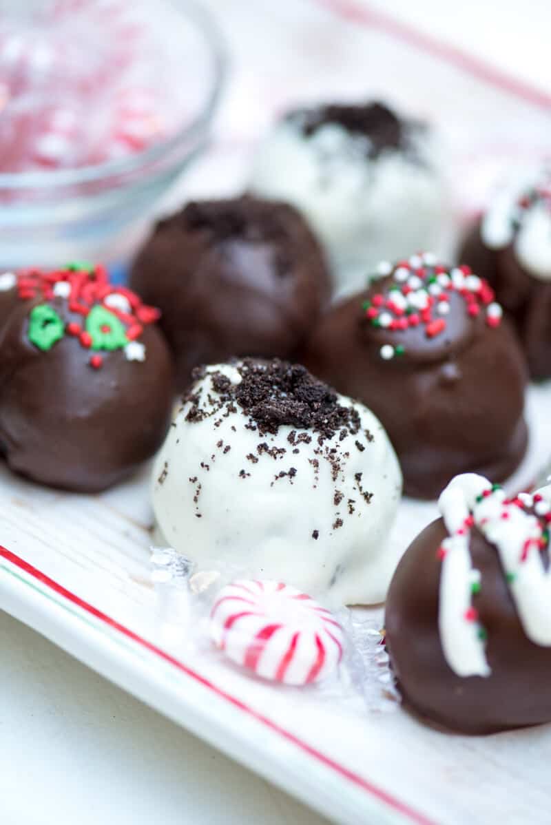 Holiday Oreo Cookie Balls on a tray with peppermint candies.