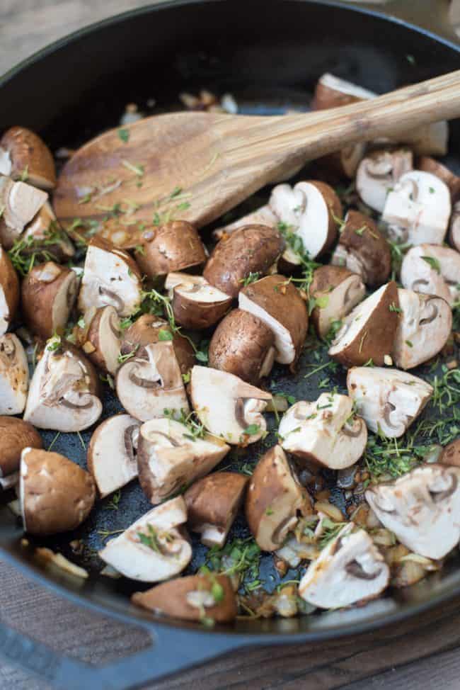 Mushrooms and fresh thyme in a cast iron skillet.