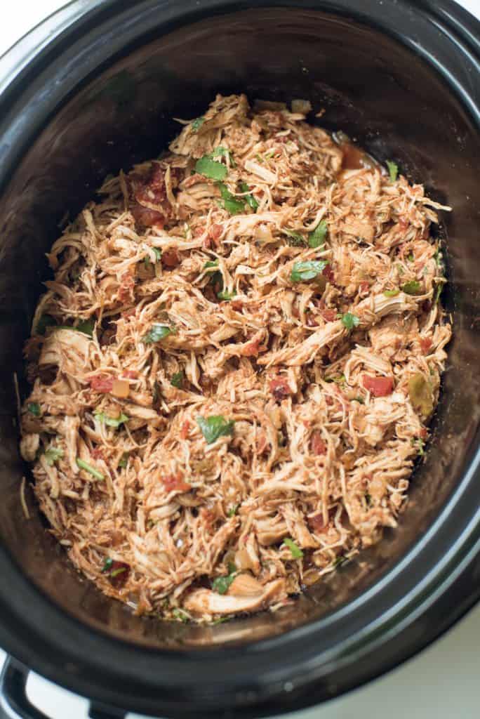 A slow cooker full of Crock-Pot Chicken Taco meat. This recipe uses pantry staples you can easily stock.