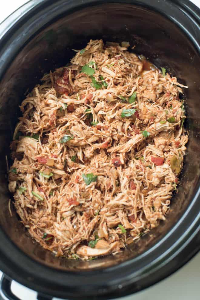 A slow cooker full of Crock-Pot Chicken Taco meat. This recipe uses pantry staples you can easily stock.