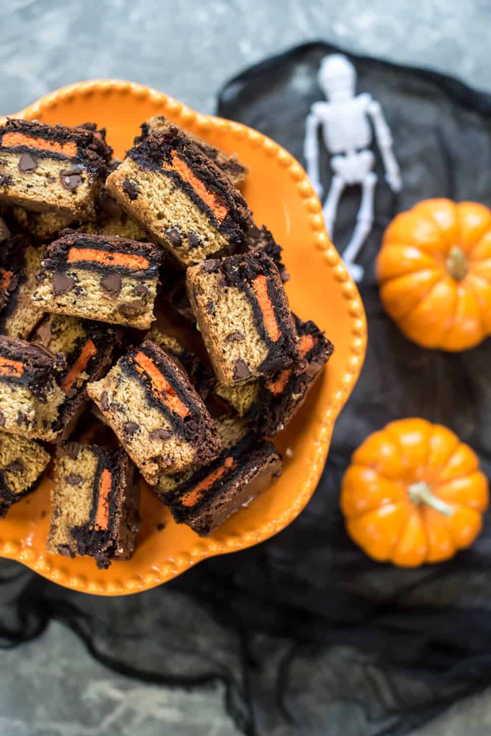 Halloween Oreo Brookie Bars on an orange platter with small pumpkins in the background.